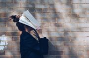 Kvinde dykker hovedet ned i bog af forvirring